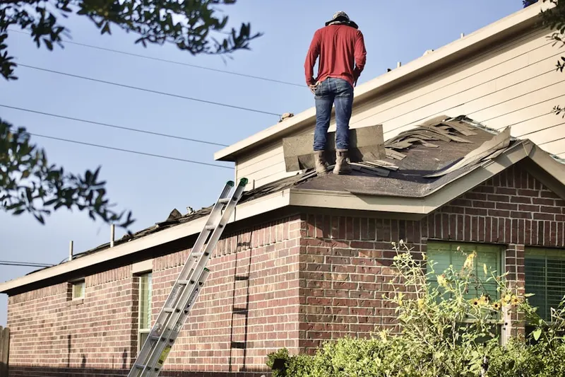 Professional roofer working on a residential roof in Stonewall